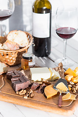 Image showing Wine, baguette and cheese on wooden background