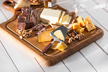 Image showing The different kind of cheese and walnuts on wooden background