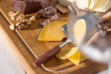 Image showing The different kind of cheese and walnuts on wooden background
