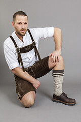 Image showing man in bavarian traditional lederhosen kneeling