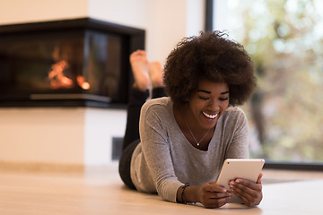 Image showing black women using tablet computer on the floor