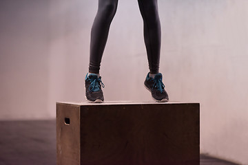 Image showing black woman is performing box jumps at gym