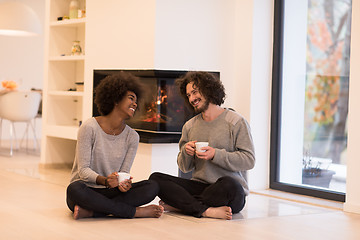 Image showing multiethnic couple  in front of fireplace