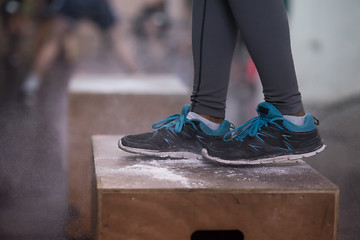 Image showing black woman is performing box jumps at gym