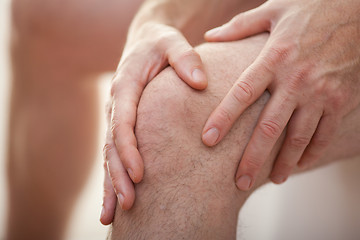 Image showing Man holding his knee