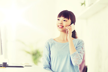 Image showing businesswoman calling on smartphone at office
