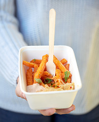 Image showing close up of hand holding plate with sweet potato