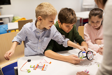 Image showing happy children building robots at robotics school