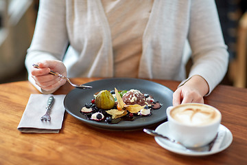 Image showing woman eating ice cream dessert with coffee at cafe