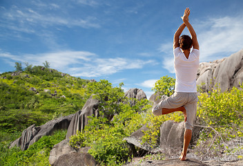 Image showing young man making yoga tree pose outdoors