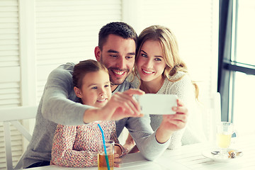 Image showing happy family taking selfie at restaurant