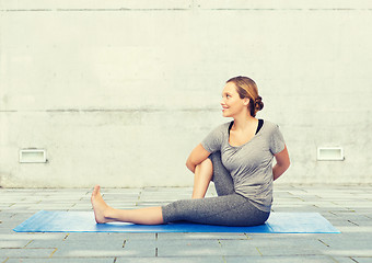 Image showing woman making yoga in twist pose on mat