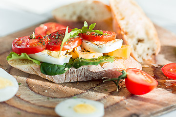 Image showing The baguette and cheese on wooden background