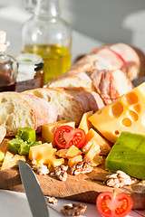 Image showing The baguette and cheese on wooden background