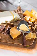 Image showing The different kind of cheese and walnuts on wooden background