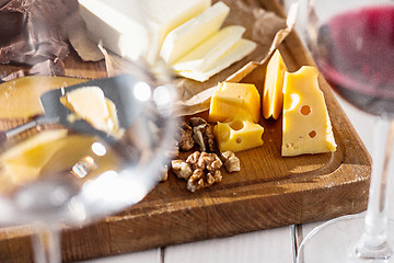 Image showing Wine, baguette and cheese on wooden background