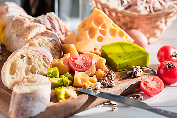 Image showing The baguette and cheese on wooden background