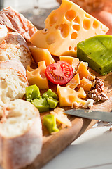 Image showing The baguette and cheese on wooden background