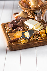 Image showing The different kind of cheese and walnuts on wooden background