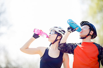 Image showing Bicyclists drink water from bottle