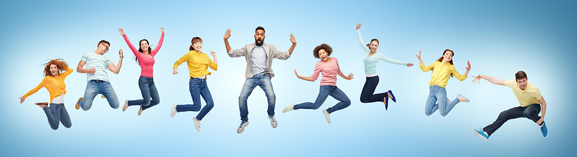 Image showing happy people or friends jumping in air over blue