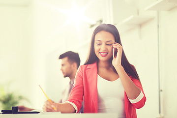 Image showing businesswoman calling on smartphone at office