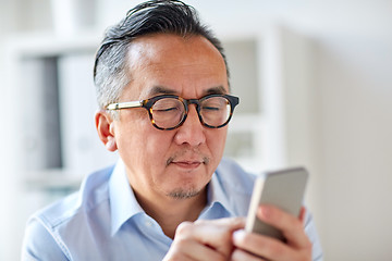 Image showing businessman texting on smartphone at office