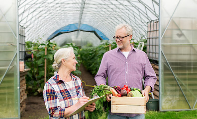 Image showing senior couple with box of vegetables on farm