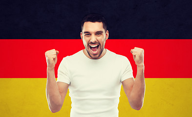 Image showing angry man showing fists over german flag