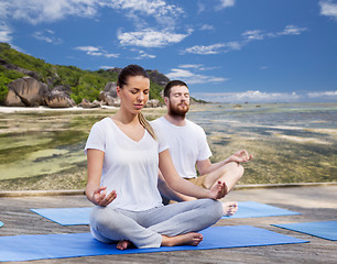 Image showing people meditating in yoga lotus pose outdoors