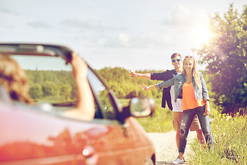 Image showing couple hitchhiking and stopping car on countryside