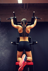 Image showing woman exercising and doing pull-ups in gym