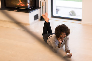 Image showing black women using tablet computer on the floor