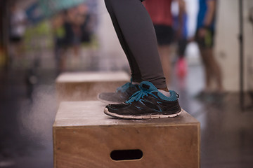 Image showing black woman is performing box jumps at gym