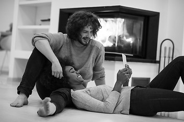 Image showing multiethnic couple used tablet computer on the floor