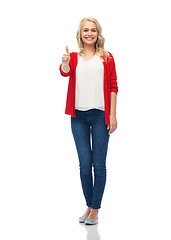 Image showing happy smiling young woman showing thumbs up