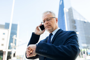 Image showing senior businessman calling on smartphone in city