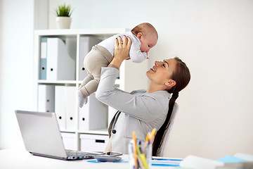 Image showing happy businesswoman with baby and laptop at office