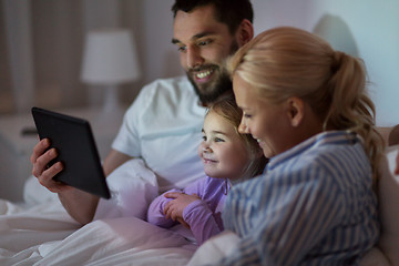 Image showing happy family with tablet pc in bed at home