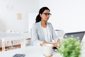 Image showing happy businesswoman with laptop at office