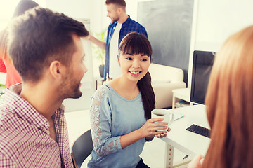 Image showing happy creative team drinking coffee at office