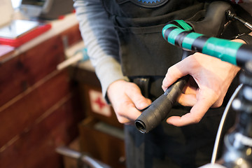 Image showing Man fixing bicycle in garage