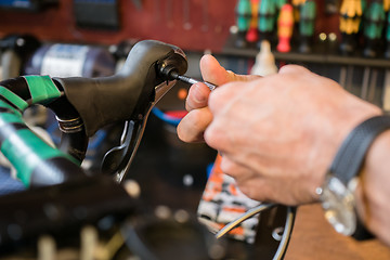 Image showing Man repairs bicycle handle screwdriver