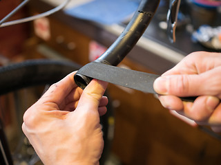 Image showing Man reeling tape on bicycle