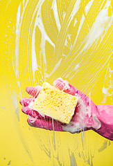 Image showing Hand washes window with sponge