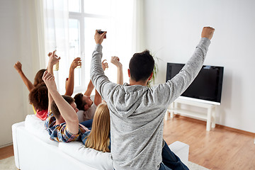 Image showing happy friends with beer watching tv at home