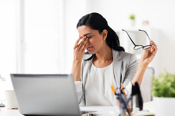 Image showing businesswoman rubbing tired eyes at office