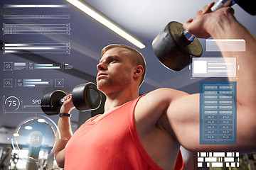 Image showing young man with dumbbells flexing muscles in gym