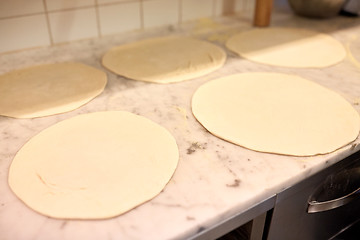 Image showing raw pizza dough on table at pizzeria