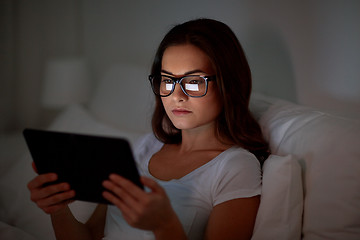 Image showing woman with glasses and tablet pc in bed at home